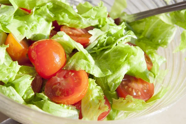 Салат з веселими помідорами та зеленим листям — стокове фото