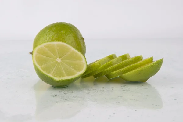 Limes juteuses fraîches sur blanc — Photo