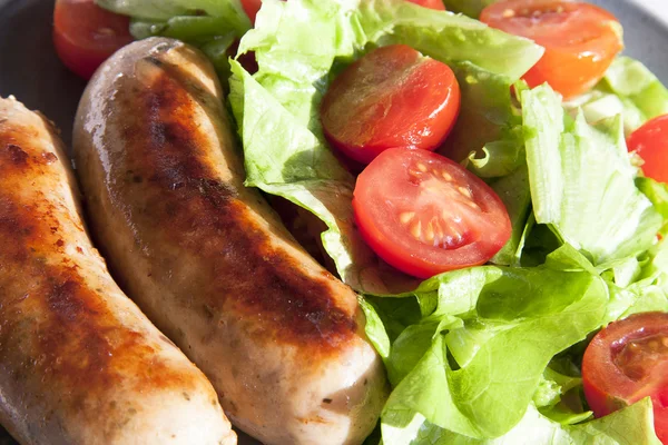 Stock image Sausages and salad with cherry tomatoes