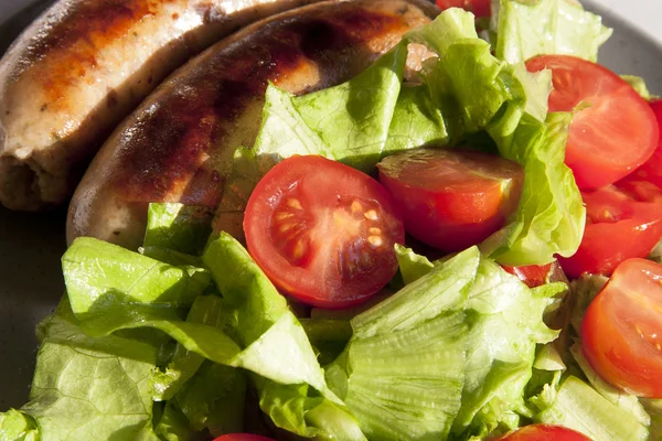 Sausages and salad with cherry tomatoes — Stock Photo, Image