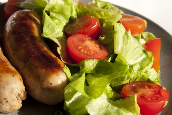 stock image Sausages and salad with cherry tomatoes