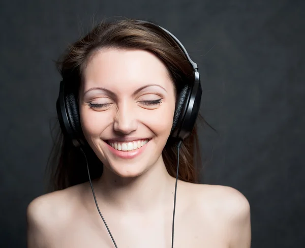 Nő fülhallgatóval zenét hallgatni — Stock Fotó
