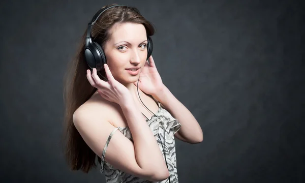 Жінка з навушниками слухає музику — стокове фото