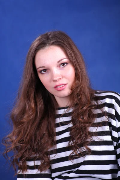 Young brunette lady posing on blue background — Stock Photo, Image