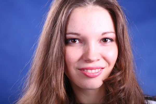 Genç kadının üzerinde mavi arka plan yüzü — Stok fotoğraf