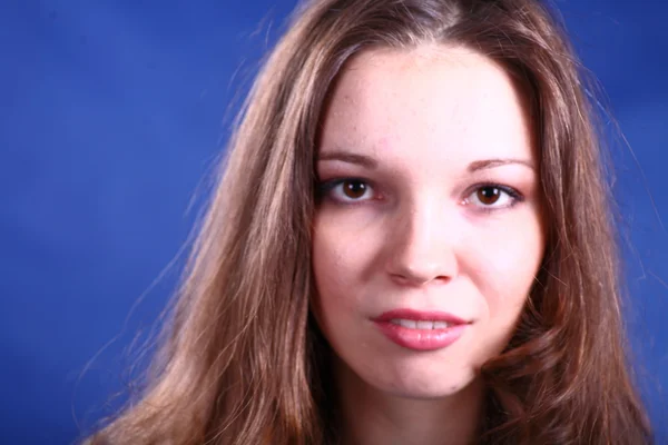 Genç kadının üzerinde mavi arka plan yüzü — Stok fotoğraf