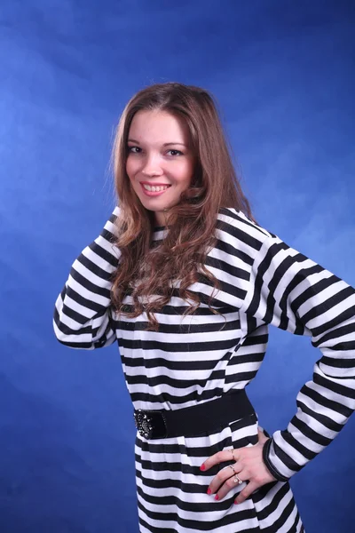 Junge brünette Dame posiert auf blauem Hintergrund — Stockfoto