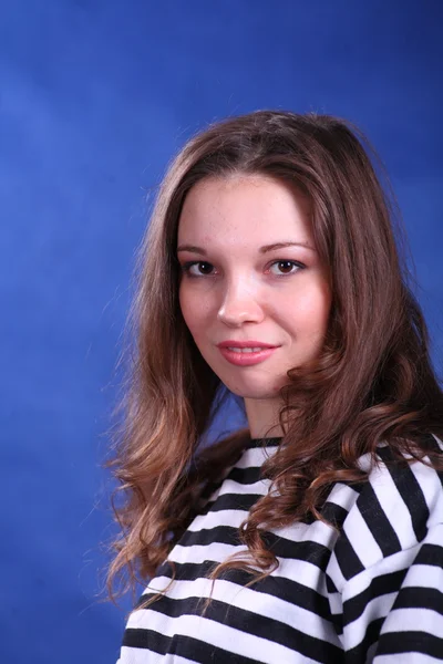 Young brunette lady posing on blue background — Stock Photo, Image
