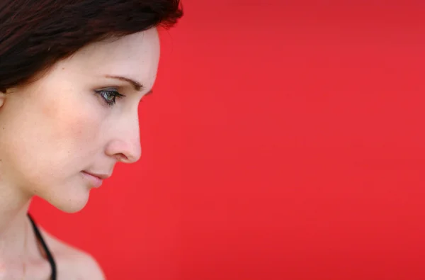 stock image Girl is posing against red wall