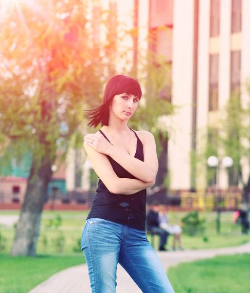 Chica está posando contra el parque — Foto de Stock