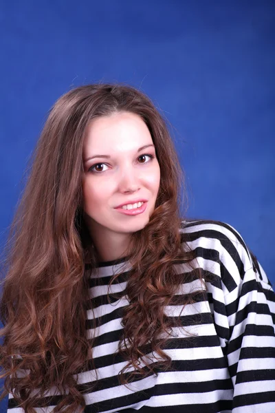 Jovem morena posando no fundo azul — Fotografia de Stock