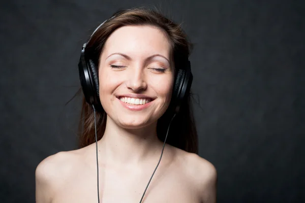 Kvinna med hörlurar lyssnar på musik — Stockfoto