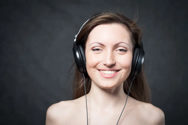 Žena se sluchátky poslech hudby — Stock fotografie