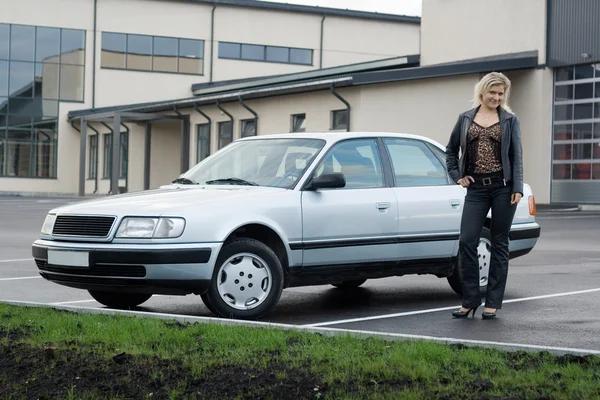 Blondes Mädchen mit Auto auf leerem Parkplatz. — Stockfoto