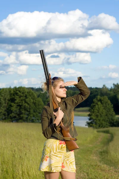 Blondie meisje met een jachtgeweer. — Stockfoto