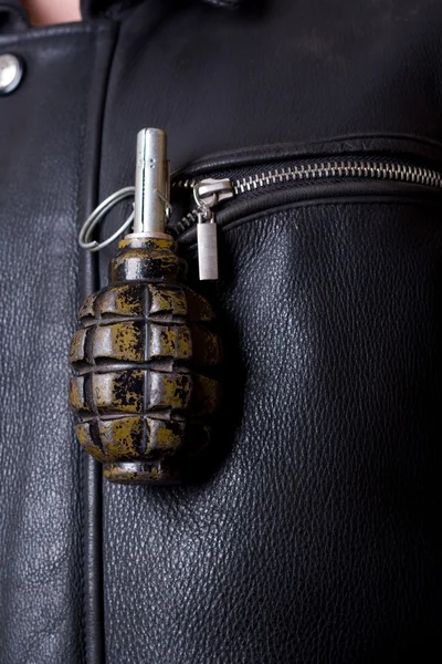 Granada de mano en el bolsillo de la chaqueta de cuero . Imagen De Stock