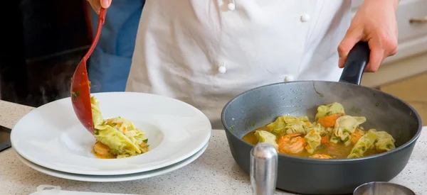 Lo chef stende i ravioli su un piatto — Foto Stock