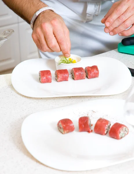 Шеф-повар украшает тарелку едой — стоковое фото