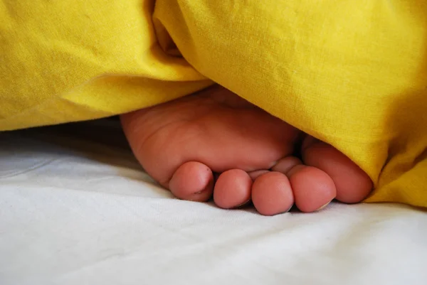 stock image Bare foot under the covers