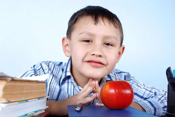 Schoolboy with red apple and books — Stock Photo, Image
