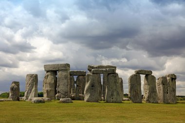 Stonehenge historic site on green grass under blue sky. Stonehen clipart