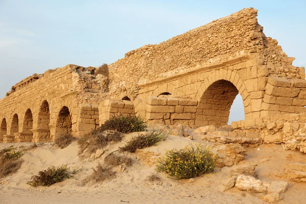 Zonsondergang op oude oude Romeinse aquaduct in Caesarea bij de kust-o — Stockfoto