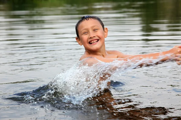 Junge im Fluss mit Spritzwasser — Stockfoto
