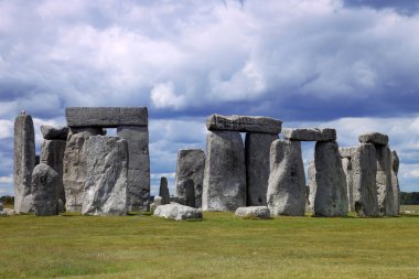 Stonehenge mavi gökyüzünün altında yeşil çimenlerin üzerinde tarihi bir site. stonehen