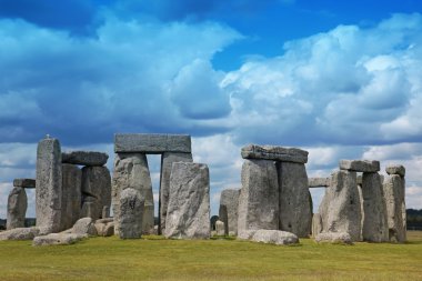 Stonehenge historic site on green grass under blue sky. Stonehen clipart