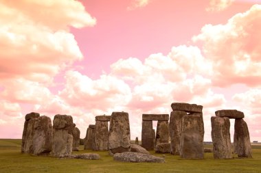 Stonehenge mavi gökyüzünün altında yeşil çimenlerin üzerinde tarihi bir site. stonehen