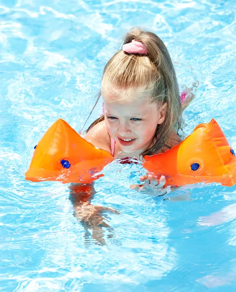 Niño con brazaletes jugando en la piscina . — Foto de Stock