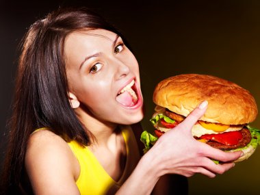 Woman eating hamburger. clipart