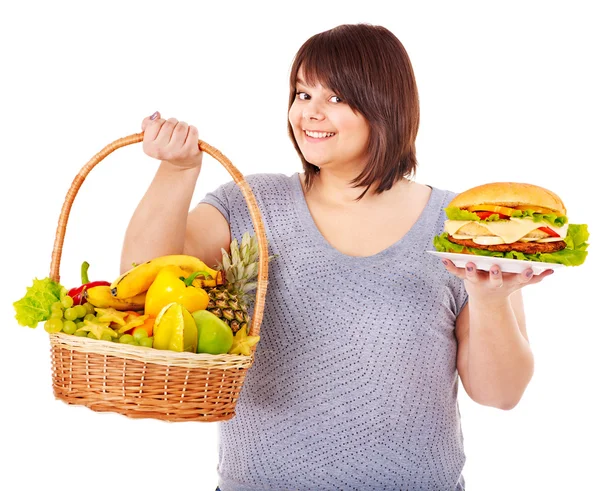 Nő választás között a gyümölcs- és hamburger. — Stock Fotó