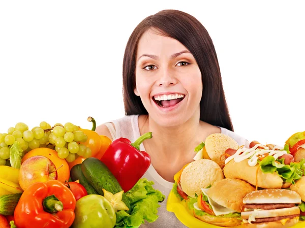 Mujer eligiendo entre fruta y hamburguesa . — Foto de Stock