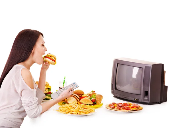 Vrouw eten fastfood en het kijken naar tv. — Stockfoto