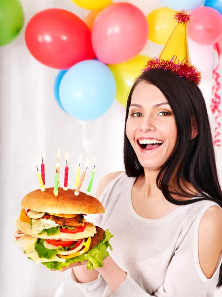 Žena jíst hamburger na narozeniny. — Stock fotografie