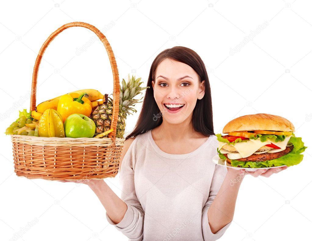 Woman choosing between fruit and hamburger.