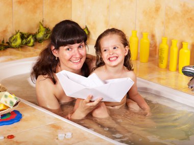 Mother and daughter washing in bath. clipart