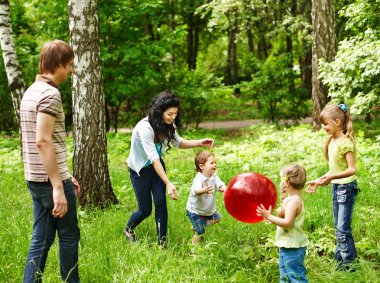 Outdoor happy family plaing ball . clipart