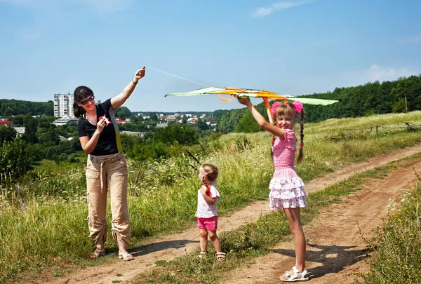 Mutlu bir aile ve çocuklar uçurtma uçurmak. — Stok fotoğraf