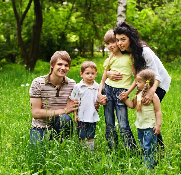 Venkovní rodina s dětmi, na zelené trávě. — Stock fotografie