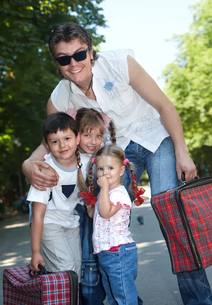 Отец и дети в парке с чемоданом . — стоковое фото