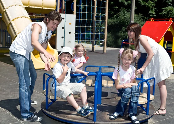 Familia feliz y tres hijos en el parque. — Stockfoto