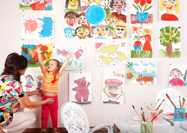 Öğretmen ile çocuk odasında boyalar çizmek. — Stok fotoğraf