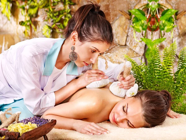 Frau bekommt Kräuterkompresse-Massage. — Stockfoto