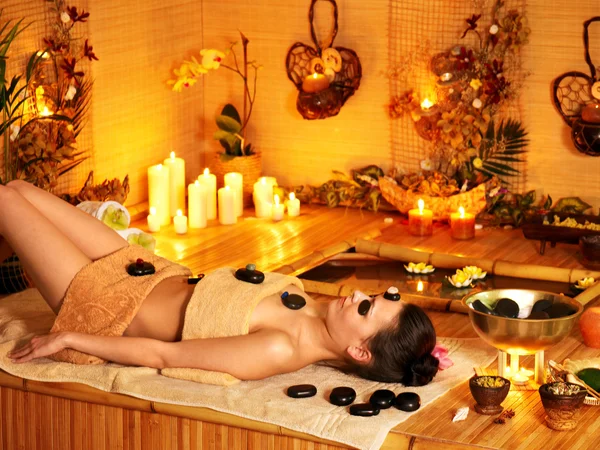 Kobieta coraz masaż gorącymi kamieniami . — Zdjęcie stockowe