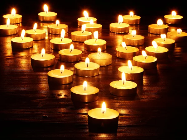 Gruppe von Kerzen auf schwarzem Hintergrund. — Stockfoto