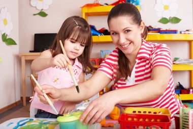 Child with teacher in preschool. clipart