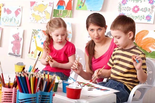 Barn målar med lärare i skolan. — Stockfoto