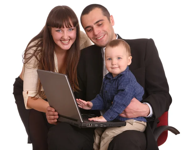 Dizüstü bilgisayar ile mutlu bir aile sandalyede oturmak. — Stok fotoğraf